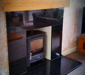 Black flecked granite fireplace